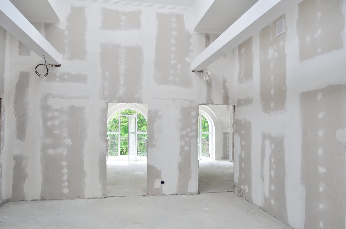 Unpainted interior of a new home under construction showing freshly installed drywall