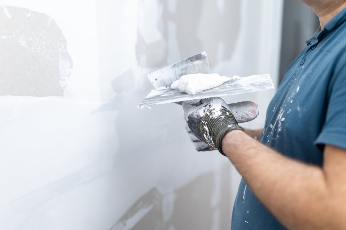 Close up of joint compound on a trowel being prepared for drywall finishing